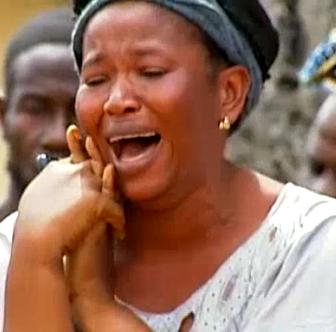 This woman weeps as the body of a friend is taken away by the burial team.