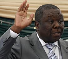 New Zimbabwean PM raises his hands as he takes the oath of office